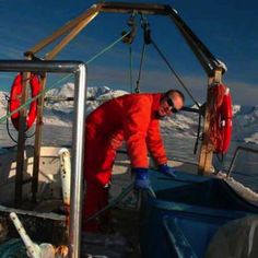 a man in an orange coverall working on a boat