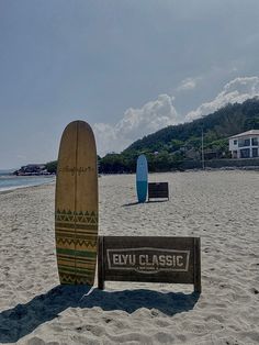 two surfboards sitting on top of a sandy beach