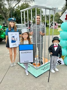 two children and an adult are standing in front of a jail cell with signs on it