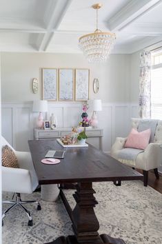 a living room filled with furniture and a chandelier above a wooden dining table