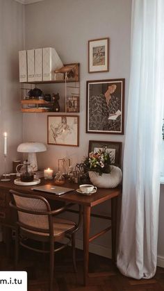 a wooden desk sitting next to a window with white flowers in vases on top of it