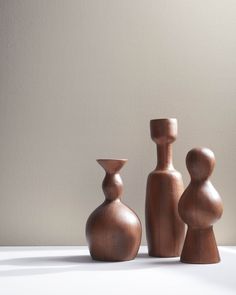 three wooden vases sitting next to each other on a table