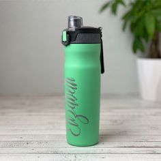 a green water bottle sitting on top of a wooden table