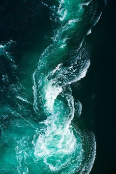 an aerial view of the ocean with waves and foamy blue water, as seen from above