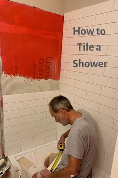 a man is painting the walls of a bathroom with red and white paint on it