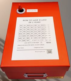 an orange box that has some sort of counting machine on top of it with the words how to save $ 500 in 1 year