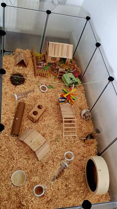 an animal cage with various animals in it and some toys on the ground next to them