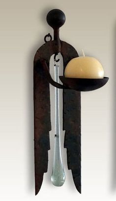 two metal objects with one holding a plate and the other holding a knife, both hanging on a wall