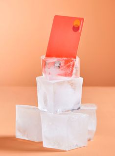 three ice cubes stacked on top of each other in front of an orange background