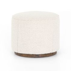 a small white ottoman with wood trim on the top and bottom, in front of a white background