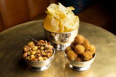 three bowls filled with different types of food on top of a metal table next to each other