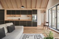 a living room filled with furniture next to a kitchen and an open floor plan on top of a hard wood floor