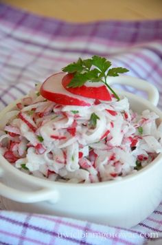 a white bowl filled with food on top of a purple and white checkered table cloth