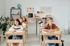 there are many children sitting at desks in the classroom