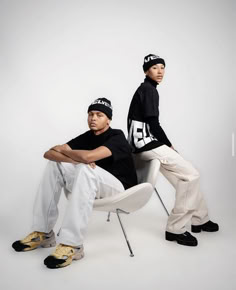 two young men sitting on top of a white chair