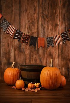 some pumpkins are sitting in front of an american flag bunting on a wooden wall