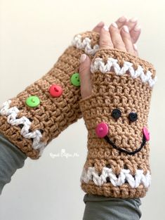 a person wearing crocheted mitts with buttons on them