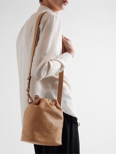 SAINT LAURENT's bucket bag is crafted from supple leather and debossed with its 'Rive Gauche' logo – the name references its first store, which opened on Paris' Left Bank in the '60s. It has an adjustable drawstring top and a detachable zipped pouch to secure smaller items, like your cards and keys. Ysl Paris, Porter Bag, Tote Bag Patters, Drawstring Top, Rive Gauche, Leather Bucket Bag, Leather Bucket, Saint Laurent Bag, Exclusive Bag