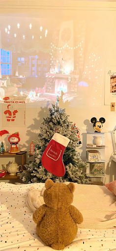 a teddy bear sitting on top of a bed next to a christmas tree