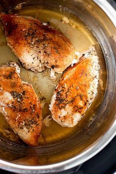 three pieces of chicken cooking in an instant pressure cooker with broth and spices