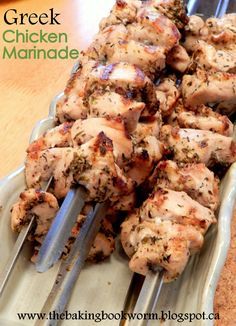 chicken marinade on a platter with tongs ready to be cut into skewers