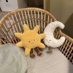 two stuffed animals sitting on top of a wicker chair next to a white pillow