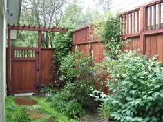 a wooden fence surrounded by lush green plants