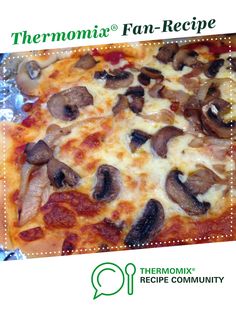 a pizza with mushrooms on it sitting on top of a piece of tin foil in front of a white background