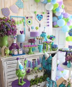 a room filled with lots of purple and green decorations on top of a wooden table