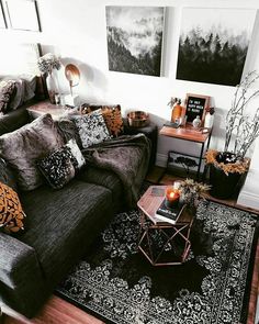 a living room filled with furniture and pictures on the wall next to a coffee table