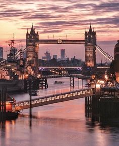 the tower bridge is lit up at night