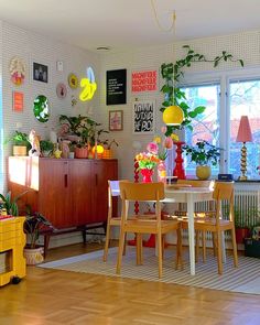 a living room filled with lots of furniture and plants on top of wooden flooring