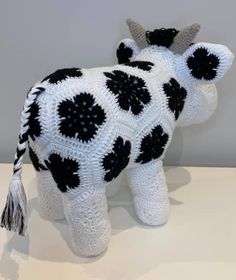 a knitted cow with black and white spots on it's body is shown