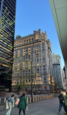 people are walking around in front of tall buildings with lights on at night, and one person is holding an american flag