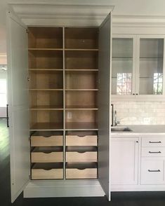 an empty kitchen with white cabinets and drawers