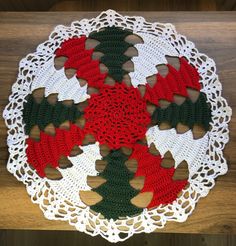 a crocheted doily with christmas decorations on the bottom and green, red and white trim