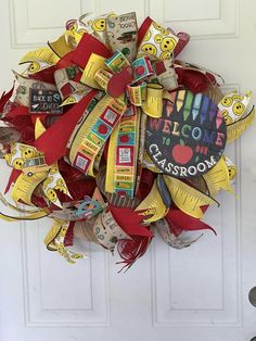 a wreath made out of school supplies is hanging on the front door to welcome students