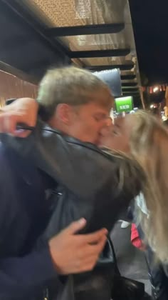 a man and woman kissing on the street