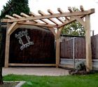 a wooden pergolan in the middle of a yard next to a fence and trees