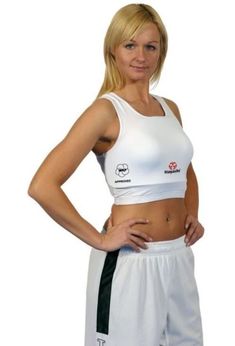 a woman is posing for the camera in her white sports bra