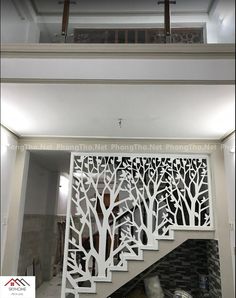 a stair case with tree cutouts on the side and handrails above it