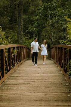 a couple walking across a bridge holding hands