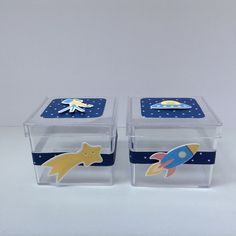 two clear storage containers with magnets on the lids and space themed stickers in them