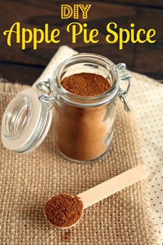 an apple pie spice in a glass jar with a wooden spoon next to it and the words diy apple pie spice