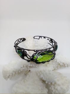 a green bracelet sitting on top of white coral