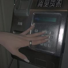 a woman's hand on an atm machine with her nails painted white and holding onto the button