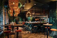 the interior of a bar with many stools and lights hanging from the ceiling above it