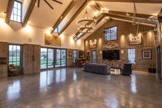 a large open room with high ceilings and wood paneling on the walls is lit by chandeliers