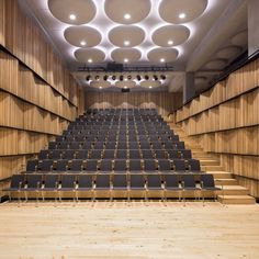 an empty auditorium with rows of seats and lights on the ceiling is seen in this image