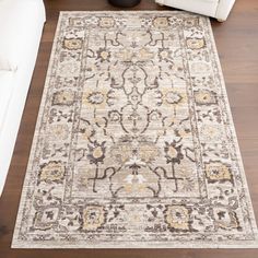 a large rug with an ornate design on the floor in front of a white couch